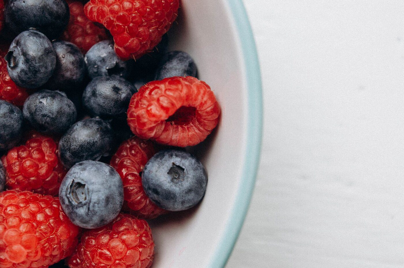 Bol de myrtilles et framboises fraîches, aliments riches en antioxydants pour une alimentation anti-inflammatoire