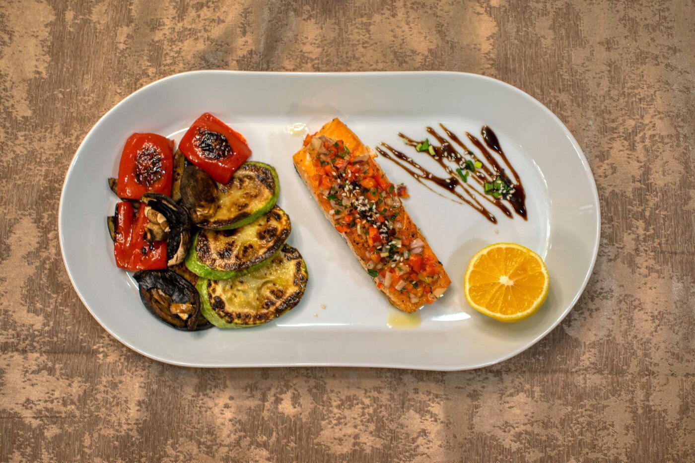 Assiette de saumon grillé et légumes rôtis, exemple d'alimentation anti-inflammatoire pour la sciatique