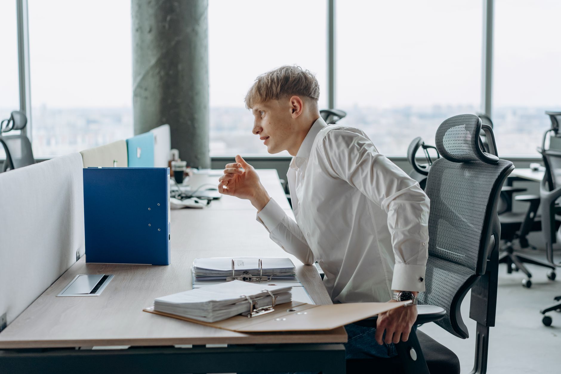 Personne assise a un bureau portant la main au bas du dos