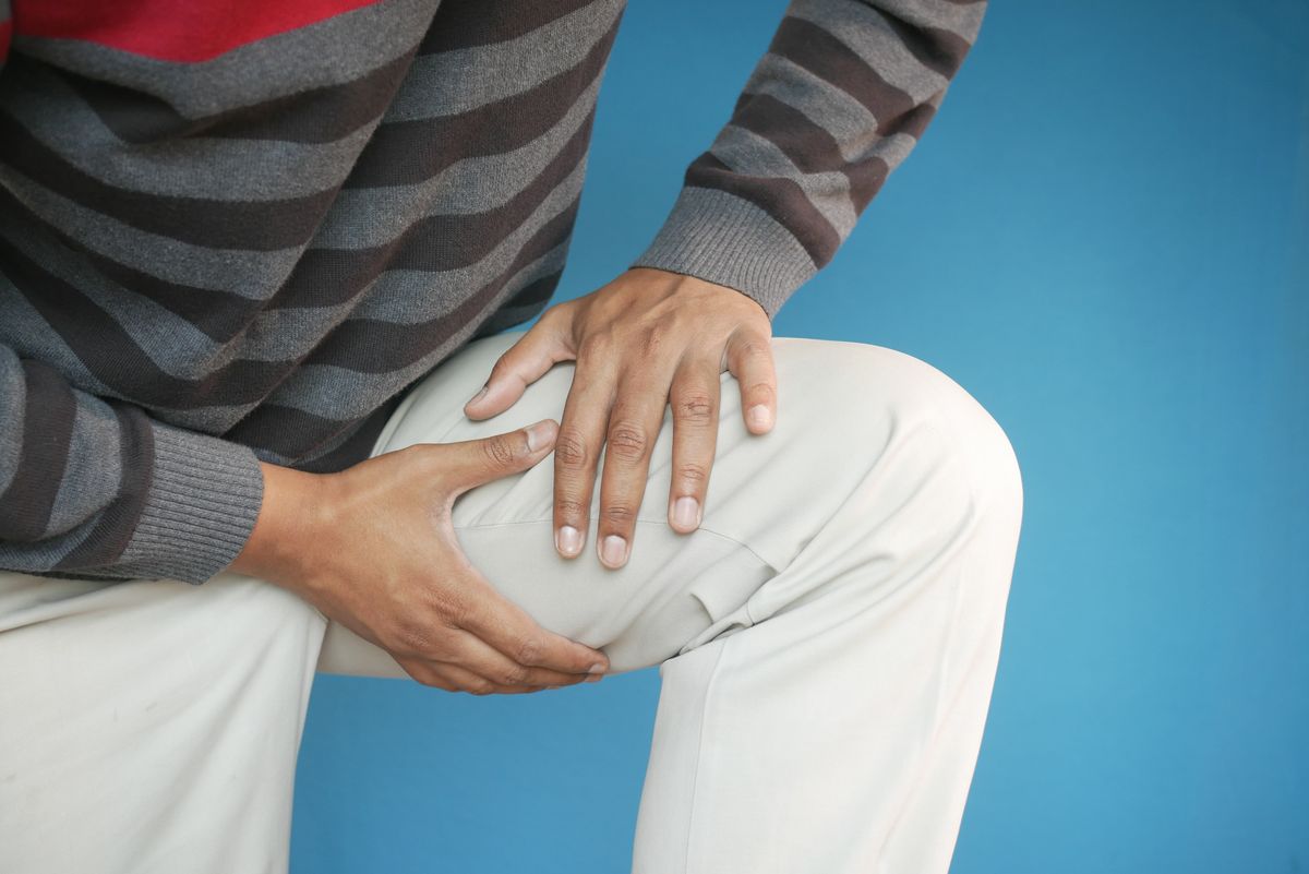 Adulte se tenant la cuisse, douleur de sciatique irradiant dans une seule jambe