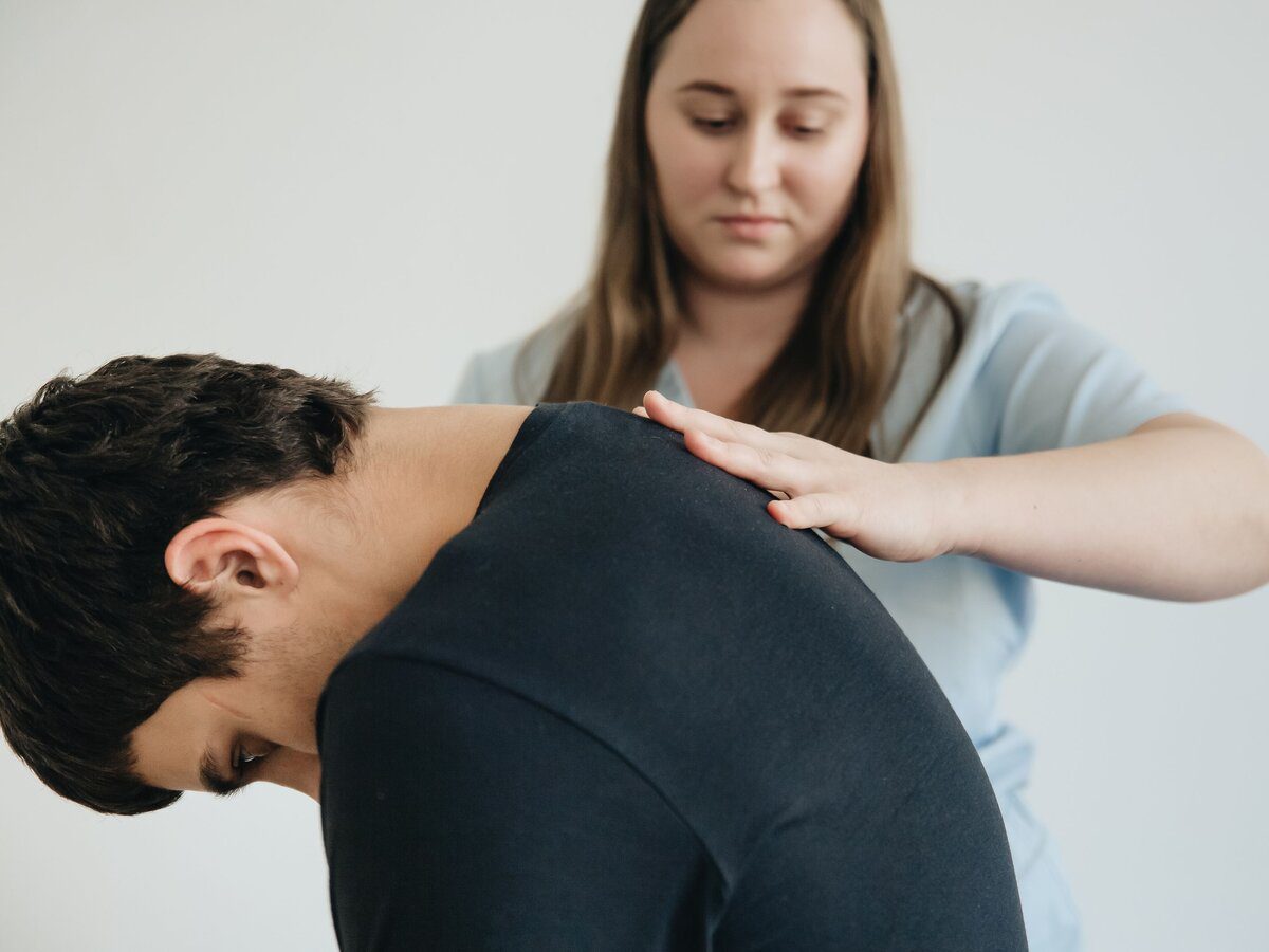 Kinésithérapeute accompagnant un patient pendant la rééducation d'une hernie discale traitée sans opération