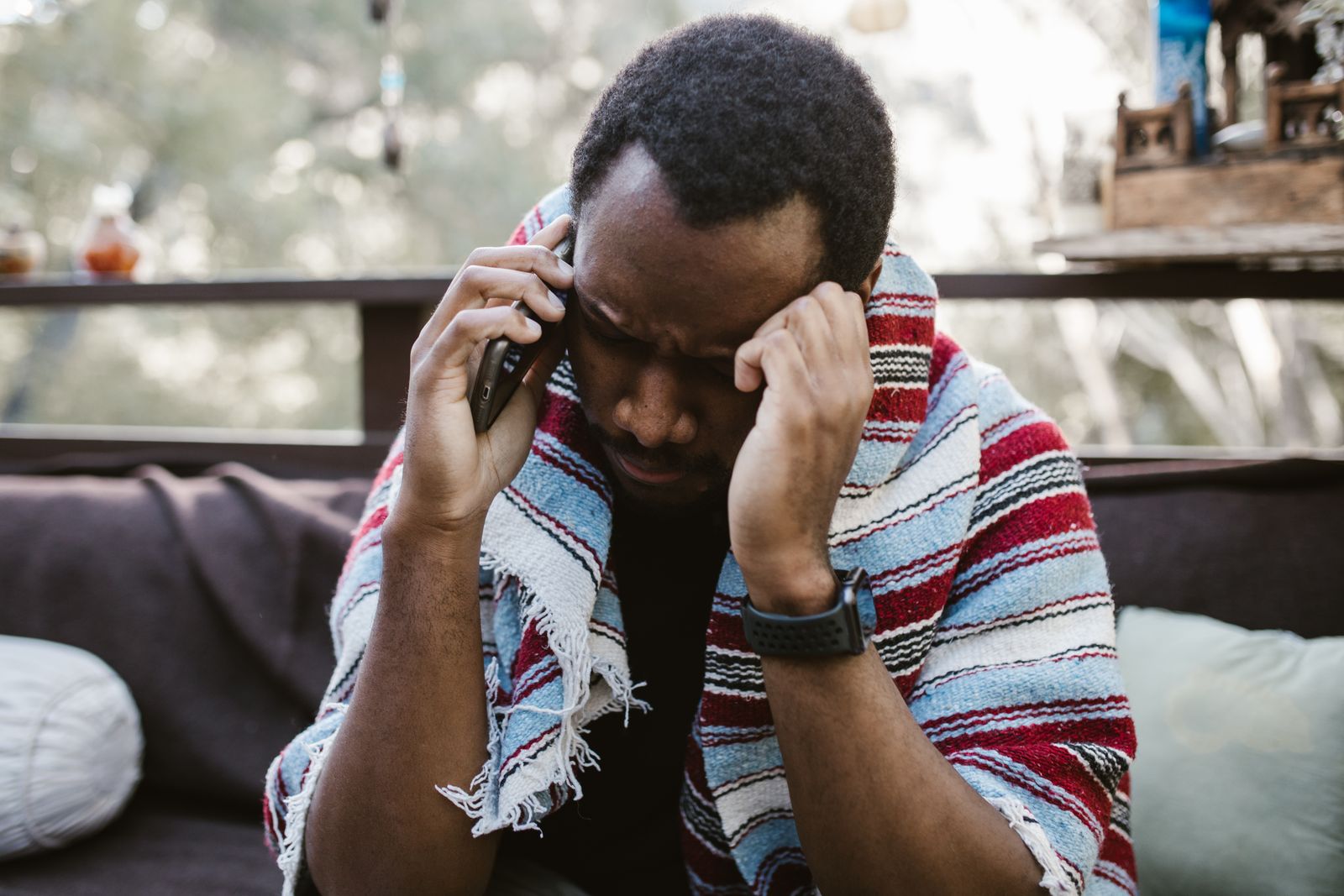 Homme inquiet au téléphone appelant son médecin en urgence, signe de sciatique paralysante ou hyperalgique